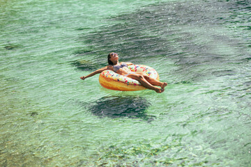 Woman Floating on Inner Tube in Water