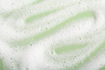 White fluffy foam on green background, top view - obrazy, fototapety, plakaty
