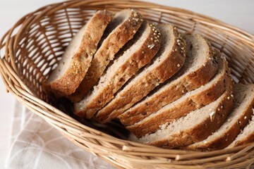 Slices of fresh homemade bread in wicker basket on table, closeup