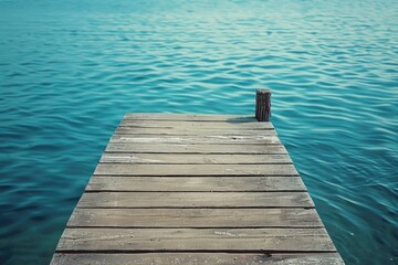 Fototapeta premium A wooden dock extending into the water. Ideal for travel and nature concepts