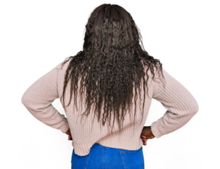 Young african woman wearing wool winter sweater standing backwards looking away with arms on body