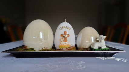 Egg-shaped candle with the word Alleluja next to porcelain eggs - Easter decoration  - obrazy, fototapety, plakaty