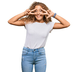 Beautiful caucasian teenager girl wearing casual white tshirt doing peace symbol with fingers over...