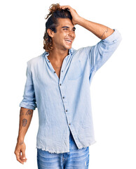 Young hispanic man wearing summer style smiling confident touching hair with hand up gesture, posing attractive and fashionable