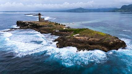 Natural background. A storm on an island in the ocean with a lighthouse.