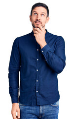 Young handsome man wearing casual shirt with hand on chin thinking about question, pensive...
