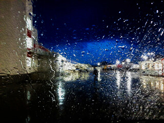 Beautiful texture, glass with raindrops, blue sky against the background of a night window in raindrops. Climat is changing.