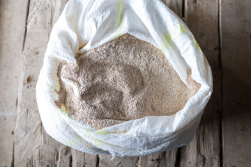 bag full of wholegrain flour on old wooden floor - 780869739