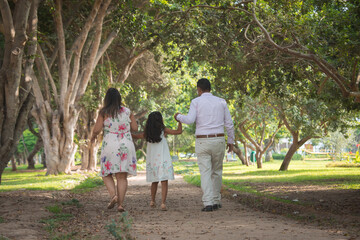 Obraz premium family walking in the park holding hands happily