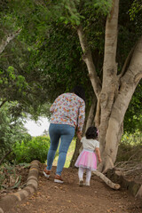 family walking in the park holding hands happily