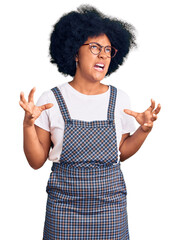 Young african american girl wearing casual clothes crazy and mad shouting and yelling with...