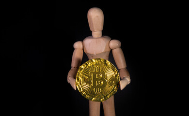 Kryptowaluta Bitcoin, postać trzymająca złoty Bitcoin  - obrazy, fototapety, plakaty