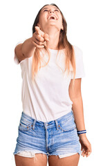 Fototapeta premium Beautiful caucasian woman wearing casual white tshirt laughing at you, pointing finger to the camera with hand over body, shame expression
