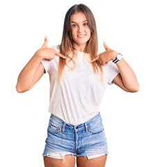 Beautiful caucasian woman wearing casual white tshirt looking confident with smile on face, pointing oneself with fingers proud and happy.