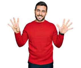 Young hispanic man wearing casual clothes showing and pointing up with fingers number nine while...