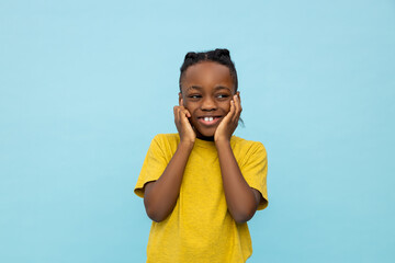Smiling dark- skinned little boy covering his ears