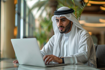 Emirati Man Working on Laptop in Modern Office