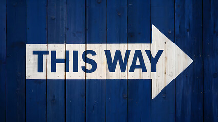 rustic white arrow sign reading “THIS WAY” against textured blue wooden backdrop