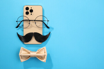 Flat lay composition with artificial moustache and glasses on light blue background, space for text