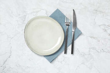 Stylish setting with elegant cutlery on white marble table, top view