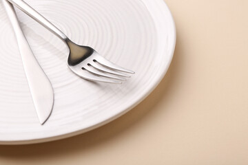 Setting with stylish cutlery on beige table, closeup. Space for text