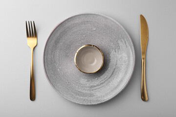 Setting with stylish cutlery on grey table, top view