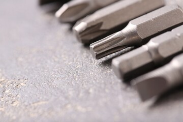 Different screwdriver bits on grey table, closeup - obrazy, fototapety, plakaty