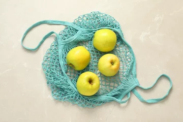 Fotobehang String bag with fresh apples on gray marble background, top view © New Africa