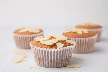 Fotobehang Muffins with fresh almond flakes on white table, closeup © New Africa