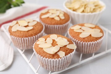 Muffins with fresh almond flakes on white table, closeup