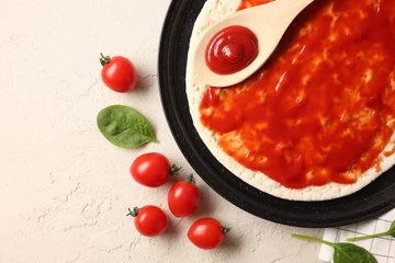 Foto op Plexiglas Pizza base smeared with sauce, tomatoes and basil on light textured table, flat lay © New Africa