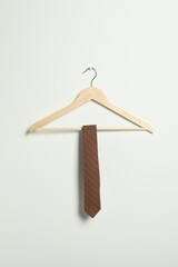 Fototapeta premium Hanger with striped necktie on white wall