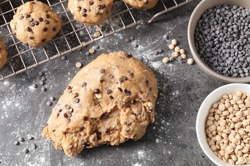Raw dough with chocolate chips on grey table, flat lay