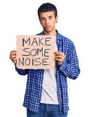 Young african amercian man holding make some noise banner thinking attitude and sober expression...