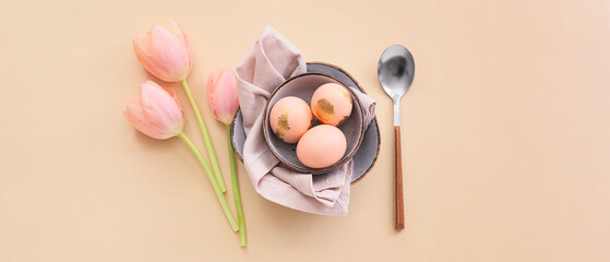 Beautiful table setting with Easter eggs and tulips on beige background