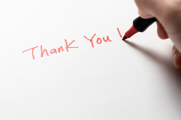 Hand written thank you message with a red pen on white background, gratitude concept. - 780891111