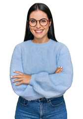 Young hispanic woman wearing casual clothes and glasses happy face smiling with crossed arms...