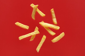 Tasty french fries on red background