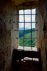 ramka w ramce, ruiny średniowiecznego zamku na górze, okno z kratami w starym zamku, partial view...