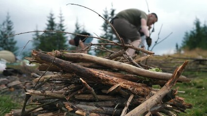 Tourists collect firewood for a fire in the mountains. Stacking wood for the fireplace