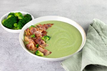 Broccoli cream soup in a white bowl on a gray background. Copy space.