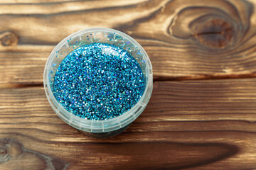 Blue Glitter Filled Container on Wooden Table. slime