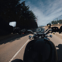 Riding an old black motorbike with black fuel deposit rider point of view on a sunny day on a...