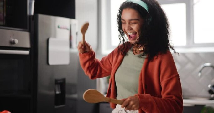 Drums, girl and music in kitchen for fun with headphones and listening to rock, audio and enjoyment with happiness. Female person, home and spoons for entertainment or rhythm, beats and energy.