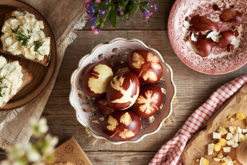 Brown Easter eggs dyed with onion peels, with slices of sourdough bread with spread made of...
