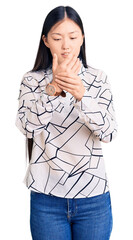 Young beautiful chinese woman wearing casual shirt suffering pain on hands and fingers, arthritis inflammation