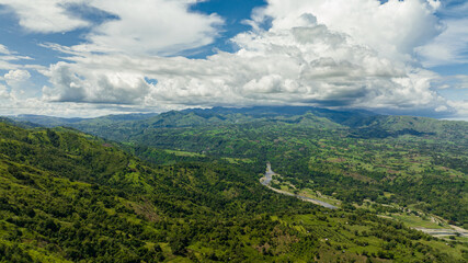 Top view of river in a mountain valley among agricultural land and rice fields. Negros, Philippines