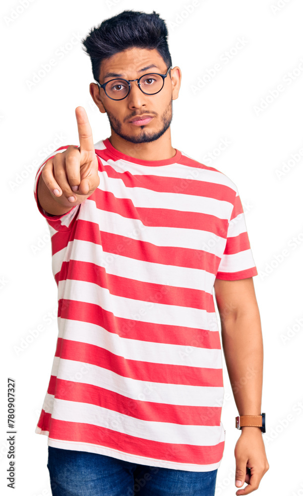 Wall mural handsome latin american young man wearing casual clothes and glasses pointing with finger up and ang