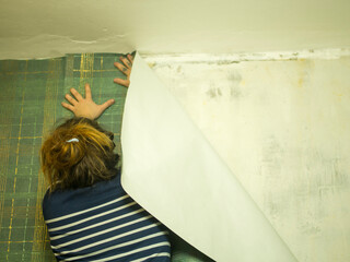 girl pasting wallpaper in the hallway, apartment renovation