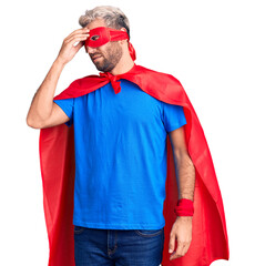 Young blond man wearing super hero custome tired rubbing nose and eyes feeling fatigue and...
